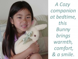 Girl with Bunny, words say, "A cozy companion at bedtime, this Bunny brings warmth, comfort, & a smile."