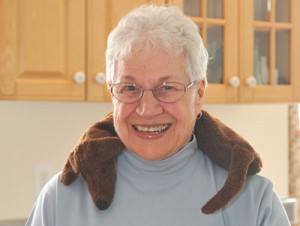 Elderly Woman using Dachshund Neck Microwave Heating Pad to relax a stiff neck from arthritis