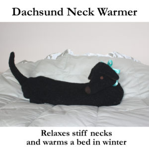 Black Dachshund Neck Warmer resting on a bed