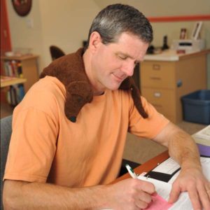 Man using Dachshund Neck Wrap as an ice pack to reduce swelling and pain