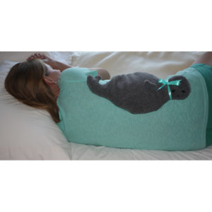 woman relaxing sore back muscles with a gray seal microwave heating pad