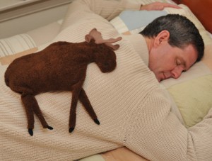 Man relaxing on a bed with a Moose microwave heating pad for the back