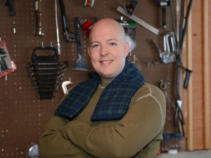 Man using extra long heating pad for his neck in a basement workshop