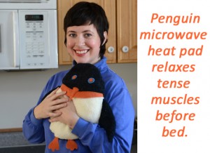 Woman holding Penguin microwave heating pad in front of a microwave oven; words say, "Penguin microwave heat pad relaxes tense muscles before bed."