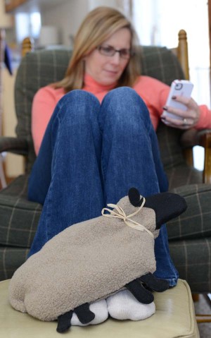 Woman warming feet with sheep microwave heating pad