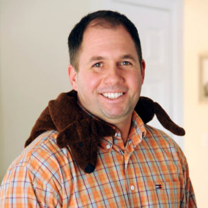 Man relaxing neck muscles with a Black Dachshund Neck Wrap