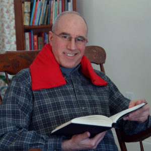 Man relaxing with red flannel neck warmer while reading