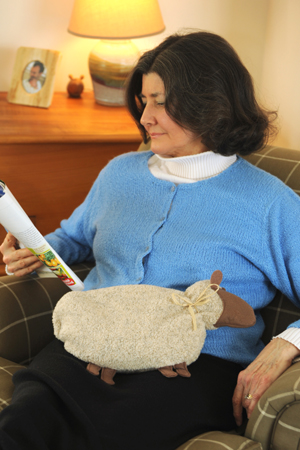 Woman relaxing with a Cozy Sheep Heating Pad from Maine Warmers