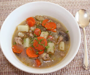 sausage soup with carrots, potatoes, and mushrooms
