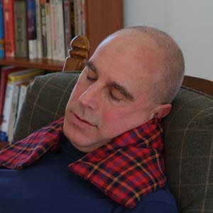 Man relaxing with microwave neck warmer