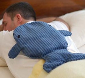 man using whale shaped microwave heating pad to help relax back muscles before surgery