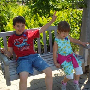 Boy and girl on swing in the Children's Garden at the Coastal Maine Botanical Garden in Boothbay, Maine