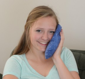 Teenage girl using Maine Ice on her face to reduce swelling from wisdom tooth extraction.