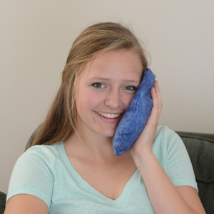 Teenage girl using Maine Ice on her face to reduce swelling from wisdom tooth extraction.