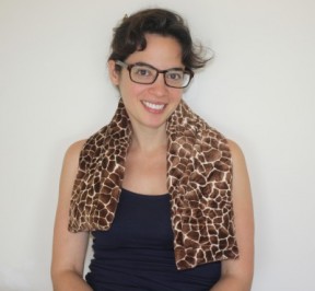 Woman relaxing with an extra long neck warmer in giraffe print extra soft plush