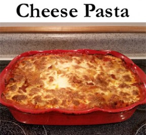 Bake Cheese Pasta in a red casserole dish cooling on a stove top