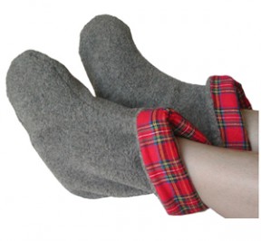 Someone resting their feet with a pair of gray foot warmers with Scotch red plaid lining that are microwaveable