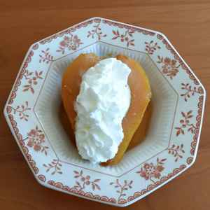 Baked half in a small dish with whipped cream on top